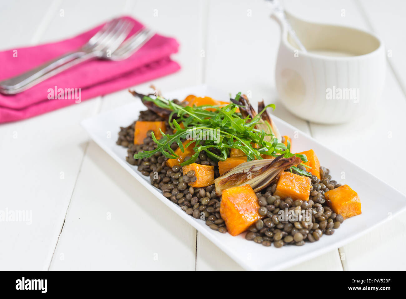 Roast squash, sweet potato and lentil salad with tahini yoghurt dressing. Stock Photo