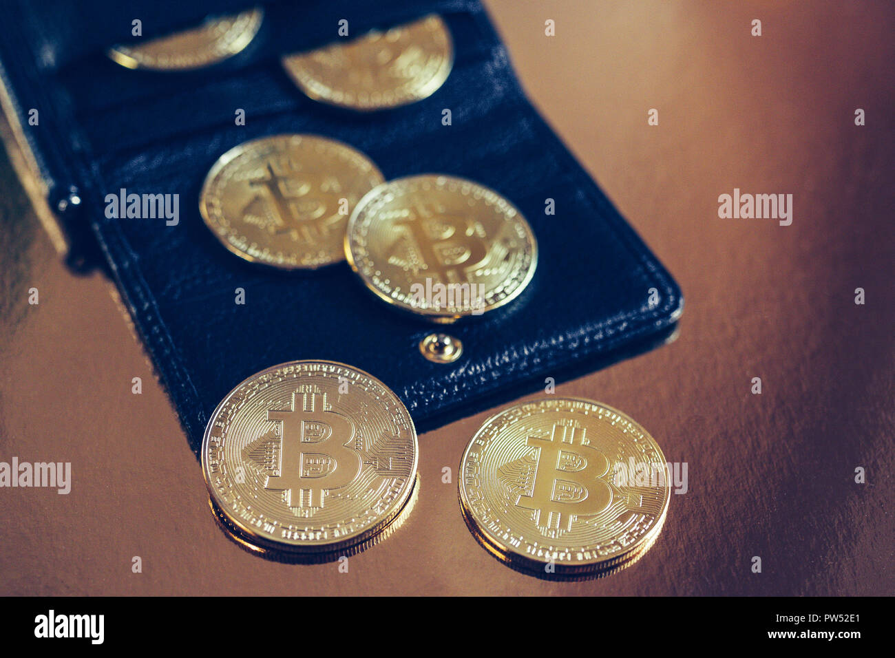 Bitcoins are scattered on the table from wallet Stock Photo