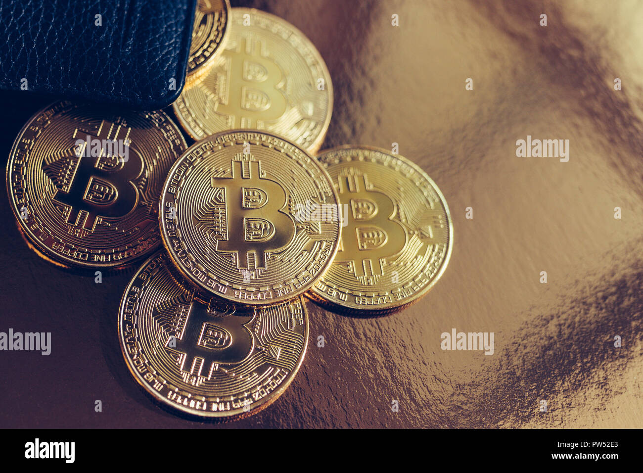 Bitcoins are scattered on the table from wallet Stock Photo