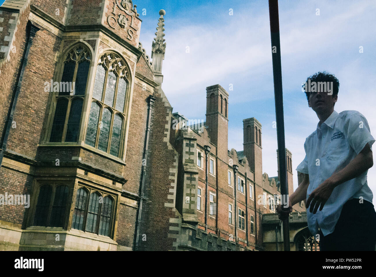 Punting in Cambridge tour guide holds the pole with a college in the background Stock Photo