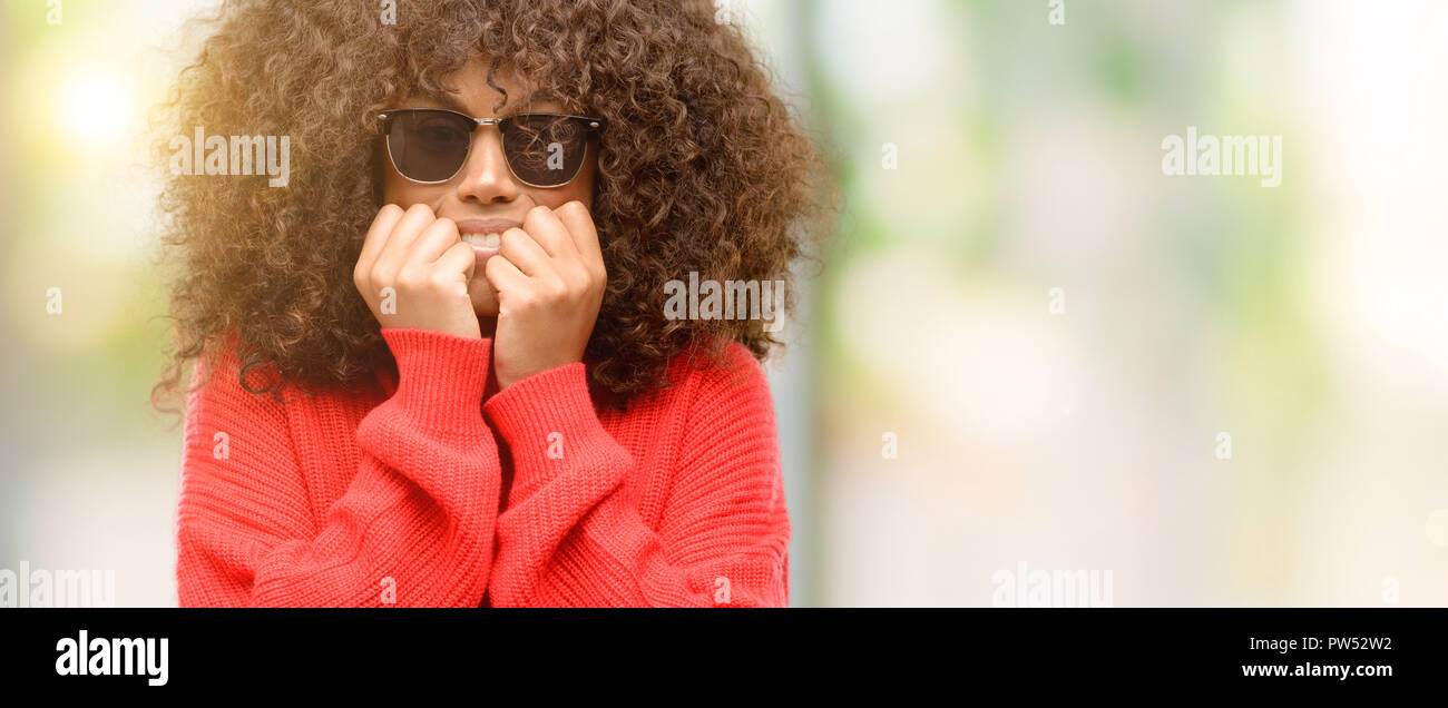 African american woman wearing sunglasses terrified and nervous
