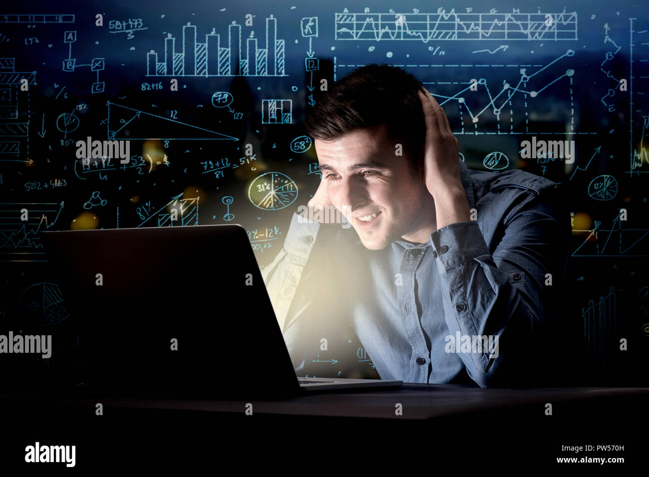 Young handsome businessman working late at night in the office with ...