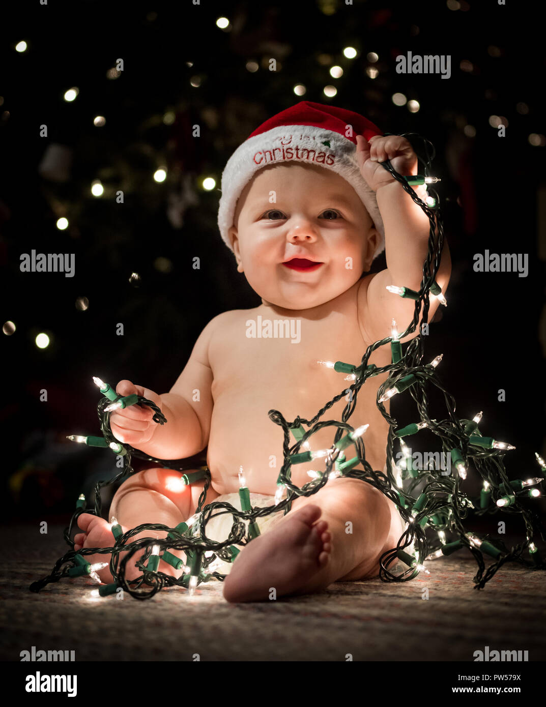 Baby at Christmas with Tree Lights Stock Photo Alamy