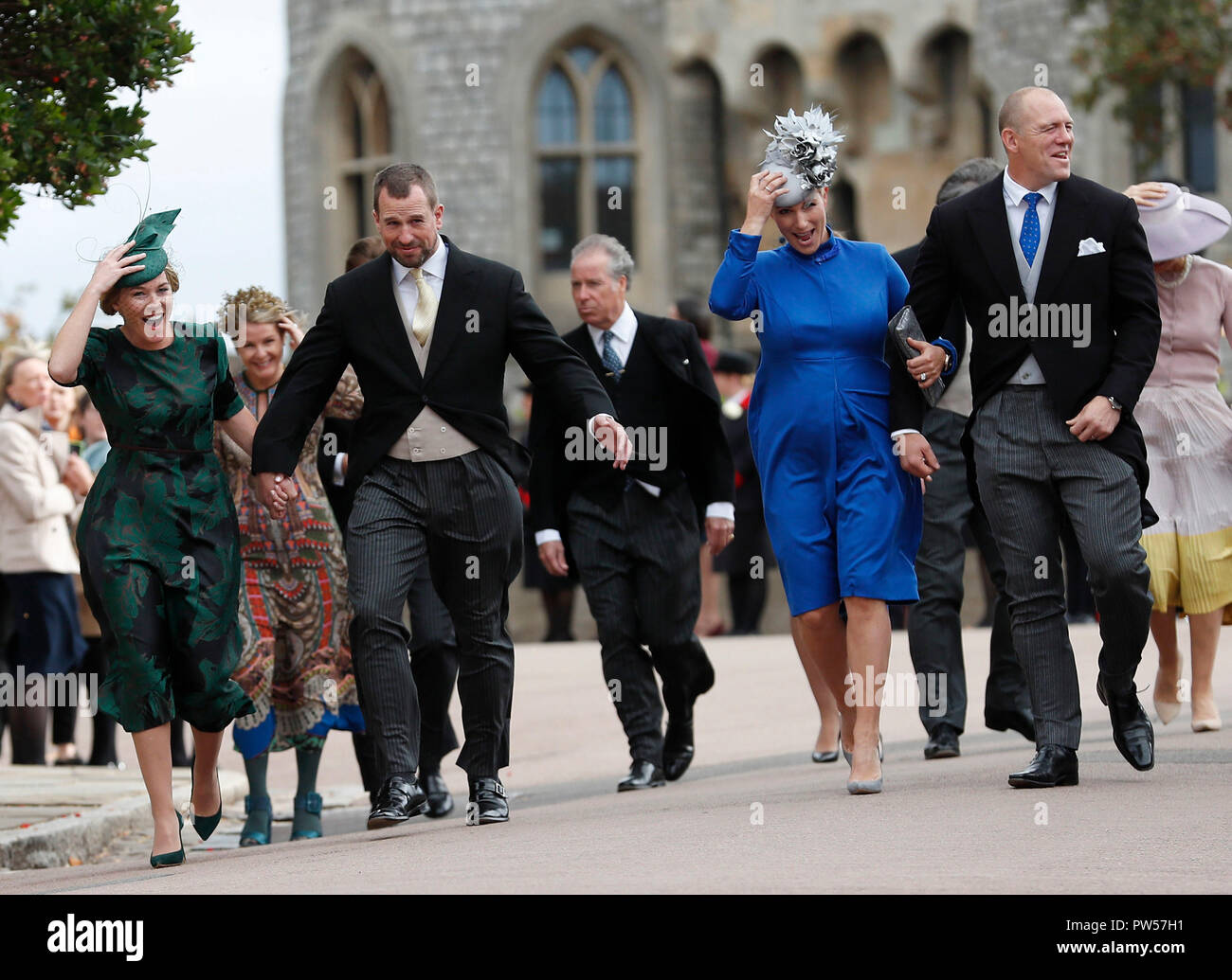 Autumn Phillips, with Peter Phillips, Zara Tindall, and Mike Tindal, hold  onto their hats as they arrive for the wedding of Princess Eugenie of York  and Jack Brooksbank in St George's Chapel,