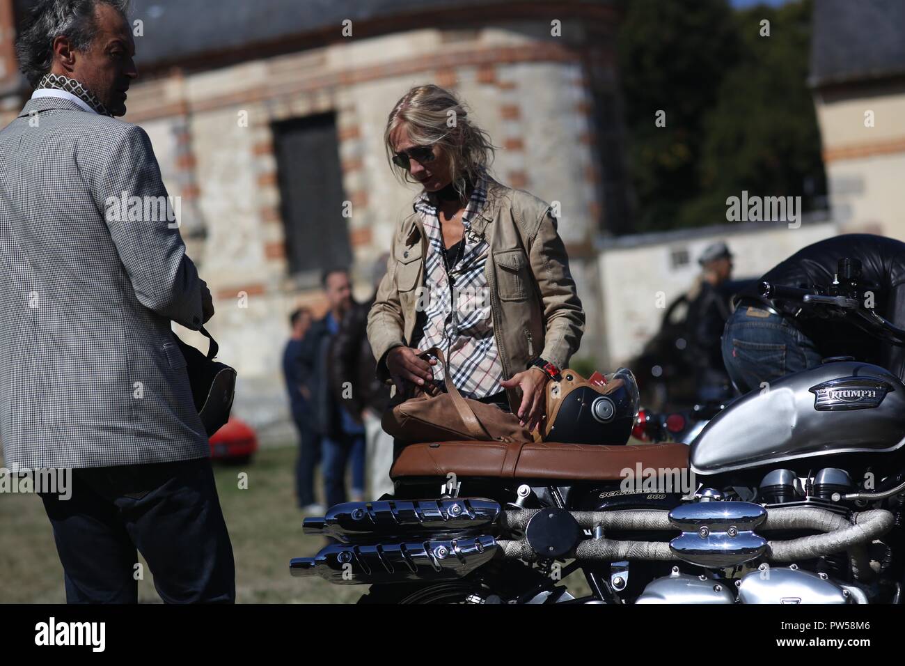 Two up on a Triumph Scrambler at Château de Neuville in Gambais (78) – France. Stock Photo