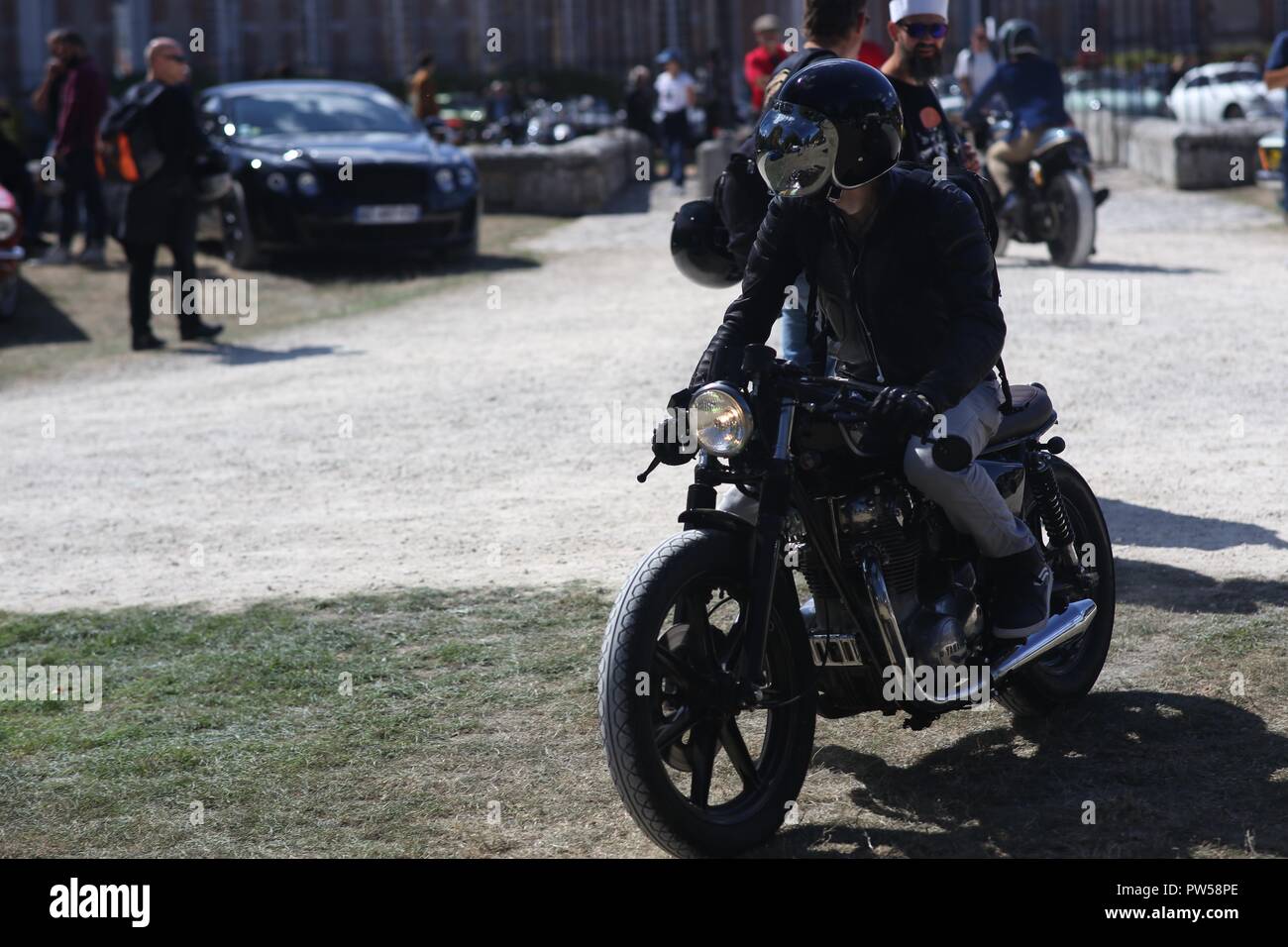 Hipster on his Yamaha XS arriving at Château de Neuville in Gambais (78) – France. Stock Photo