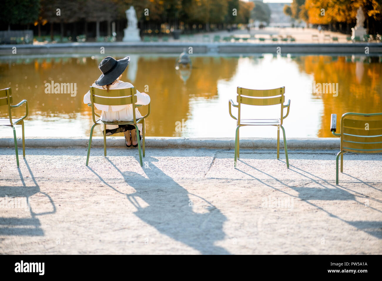 Woman In Hat Sitting Back On The Famous Green Chair Near The