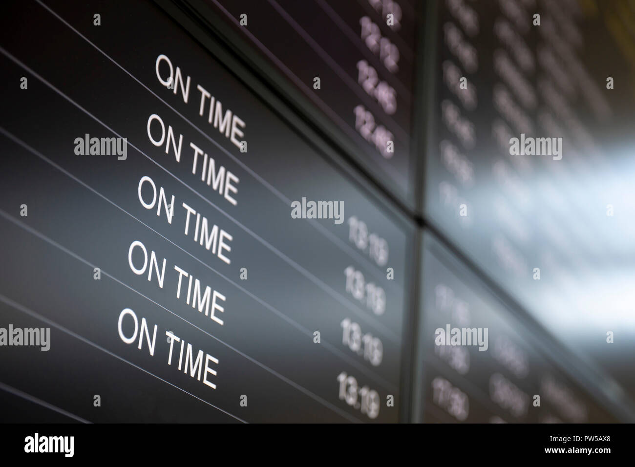 Boarding time monitor screens - timetable boards. Arrivals and departures monitors to check the status of a flight on the airport. On time sign. Stock Photo