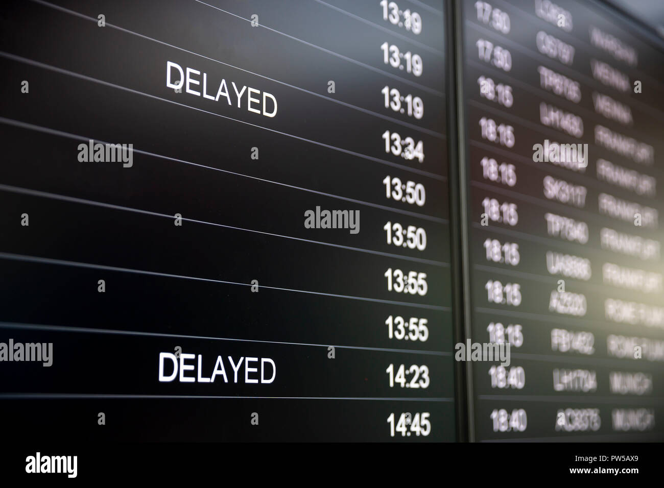Boarding time monitor screens - timetable boards. Arrivals and departures monitors to check the status of a flight on the airport. Delayed sign. Stock Photo