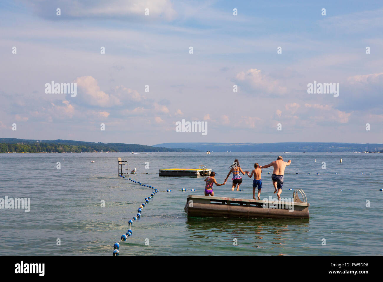 A family jumps into Skaneateles Lake, Skaneateles, New York, USA, June 14, 2013. Stock Photo