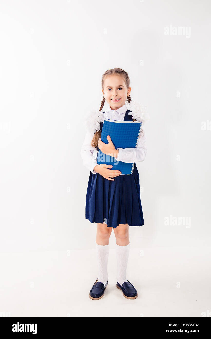 Cute schoolgirl with notebooks and books on a white background ...