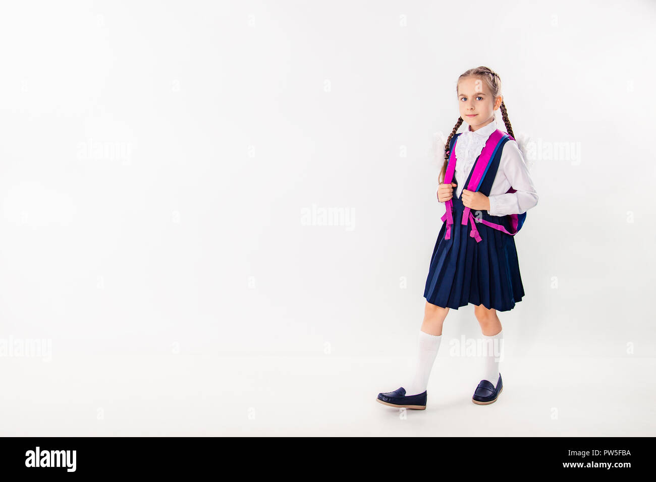 Cute schoolgirl with notebooks and books on a white background ...