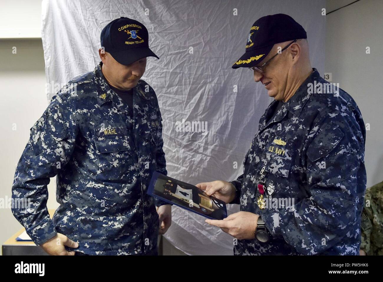 MAYPORT, Fla. (Sept. 20, 2017) Chief Engineman Timothy Wahl, the senior enlisted leader of Amphibious Squadron (PHIBRON) 4, presents Capt. Kirk A. Weatherly with a farewell gift during a change of command ceremony aboard the amphibious assault ship USS Iwo Jima (LHD 7). During the ceremony Capt. Jack L. Killman relieved Weatherly as commander, PHIBRON 4. PHIBRON 4 is composed of Iwo Jima, the transport dock ship USS New York (LPD 21) and the dock landing ship USS Oak Hill (LSD 51). Also assigned are Fleet Surgical Team (FST) 8, Tactical Air Squadron (TACRON) 22, Assault Craft Unit (ACU) 2, ACU Stock Photo