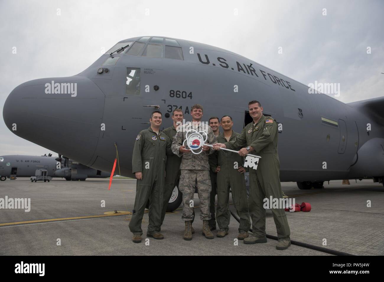 Members of the C-130J delivery team pose for a photo in front of a C-130J Super Hercules at Yokota Air Base, Japan, Sept. 20, 2107. This is the fifth C-130J delivered to Yokota and the first from Ramstein Air Base. Crewmembers from the 36th Airlift Squadron flew halfway around the world to deliver the aircraft here. Yokota serves as the primary Western Pacific airlift hub for U.S. Air Force peacetime and contingency operations. Missions include tactical airland, airdrop,aeromedical evacuation, special operations and distinguished visitor airlift. Stock Photo