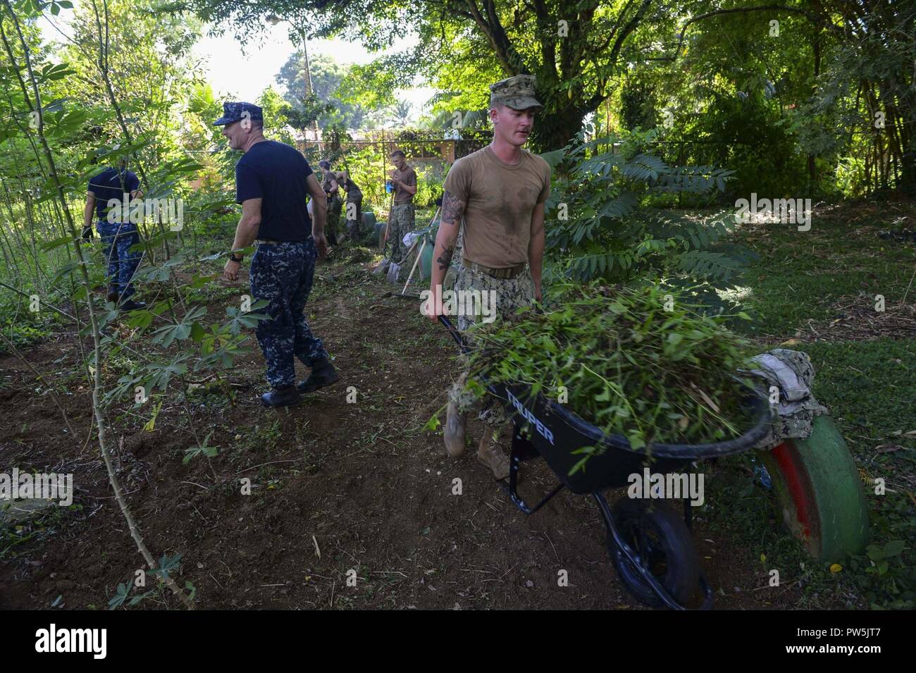 PUERTO BARRIOS, Guatemala (Sept. 20, 2017) Builder 3rd Class Herman Sebert, right, assigned to Naval Mobile Construction Battalion 1, removes weeds using a wheelbarrow during a community relations project (COMREL) at Centro De Atención Mis Años Dorados, a local nursing home, in support of Southern Partnership Station 17. SPS 17 is a U.S. Navy deployment executed by U.S. Naval Forces Southern Command/U.S. 4th Fleet, focused on subject matter expert exchanges with partner nation militaries and security forces in Central and South America. Stock Photo