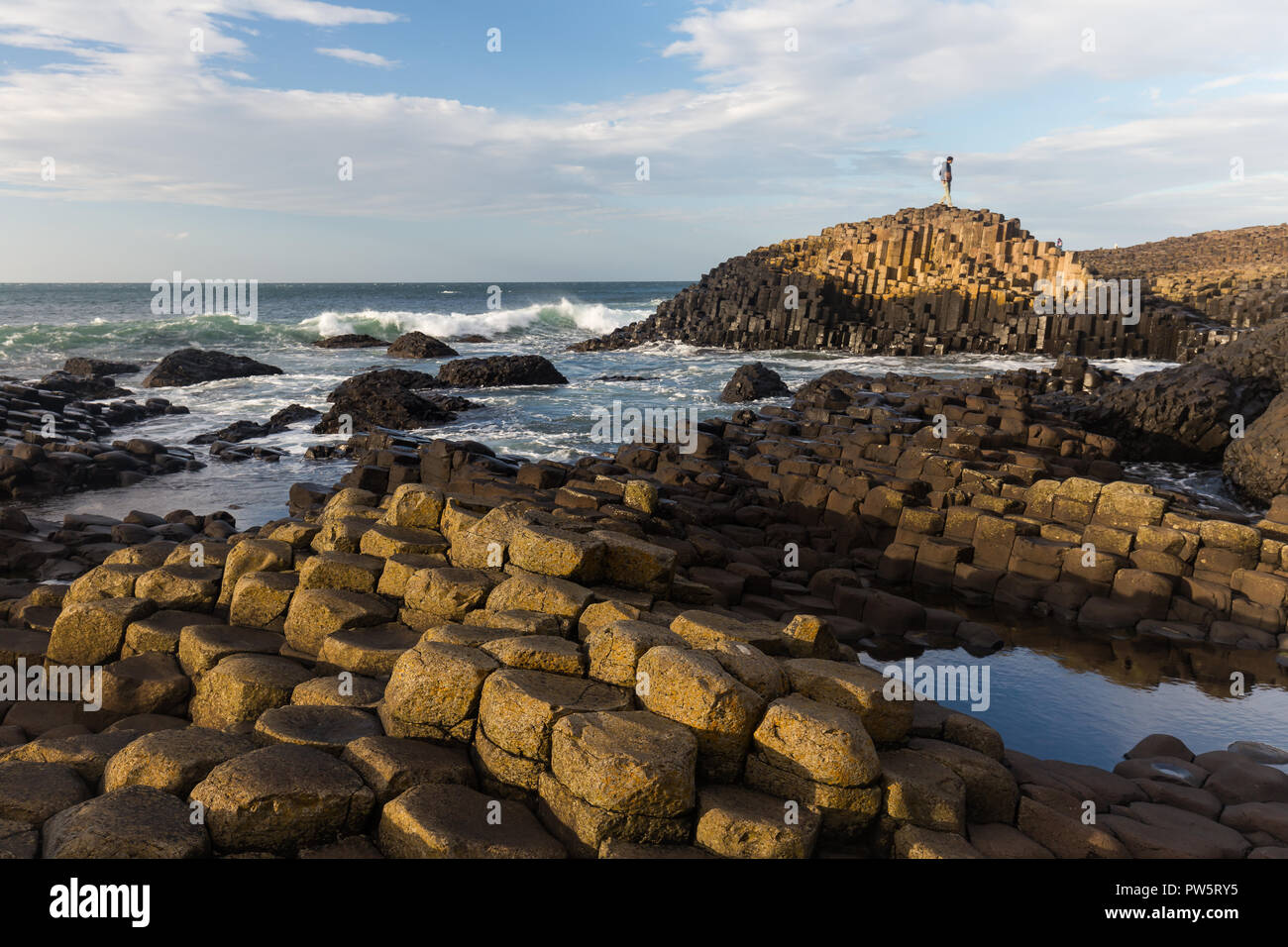 Giants Causeway, County Antrim, N.Ireland, 12th October, 2018. UK Weather: Bright sunny afternoon with strong gusts following strong winds and grey skies from Storm Callum in the morning. Tourists enjoy wonderful bright conditions at Northern Ireland’s top attraction, with thousands of basalt hexagonal columns. Credit: Ian Proctor/Alamy Live News Stock Photo