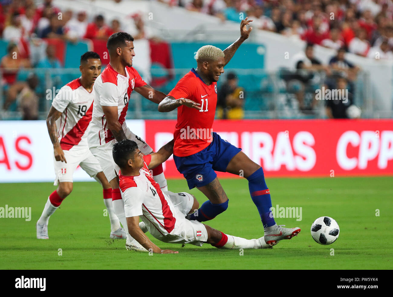 Miami Gardens, Florida, USA. 12th Oct, 2018. Chile forward JUNIOR FERNANDES (11) is fouled by Peru defender ANDERSON SANTAMARIA (4) during an international friendly match between the Peru and Chile national soccer teams, at the Hard Rock Stadium in Miami Gardens, Florida. Credit: Mario Houben/ZUMA Wire/Alamy Live News Stock Photo