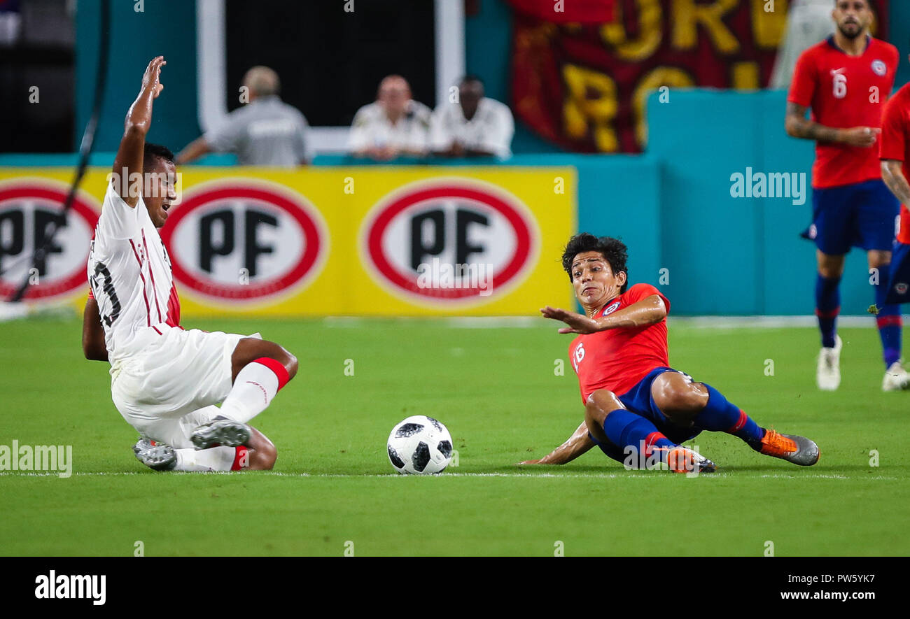 Miami Gardens, Florida, USA. 12th Oct, 2018. Peru midfielder RENATO TAPIA (13) goes for the ball defended by Chile midfielder MATIAS FERNANDEZ (16) during an international friendly match between the Peru and Chile national soccer teams, at the Hard Rock Stadium in Miami Gardens, Florida. Credit: Mario Houben/ZUMA Wire/Alamy Live News Stock Photo