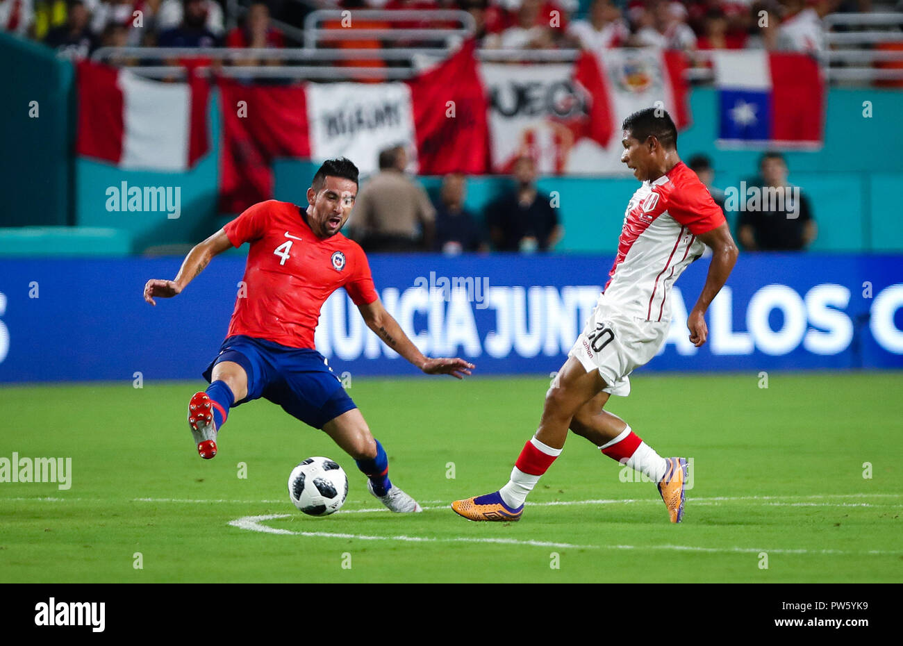 Miami Gardens, Florida, USA. 12th Oct, 2018. Chile defender MAURICIO ISLA (4) goes for the ball against Peru midfielder EDISON FLORES (20) during an international friendly match between the Peru and Chile national soccer teams, at the Hard Rock Stadium in Miami Gardens, Florida. Credit: Mario Houben/ZUMA Wire/Alamy Live News Stock Photo