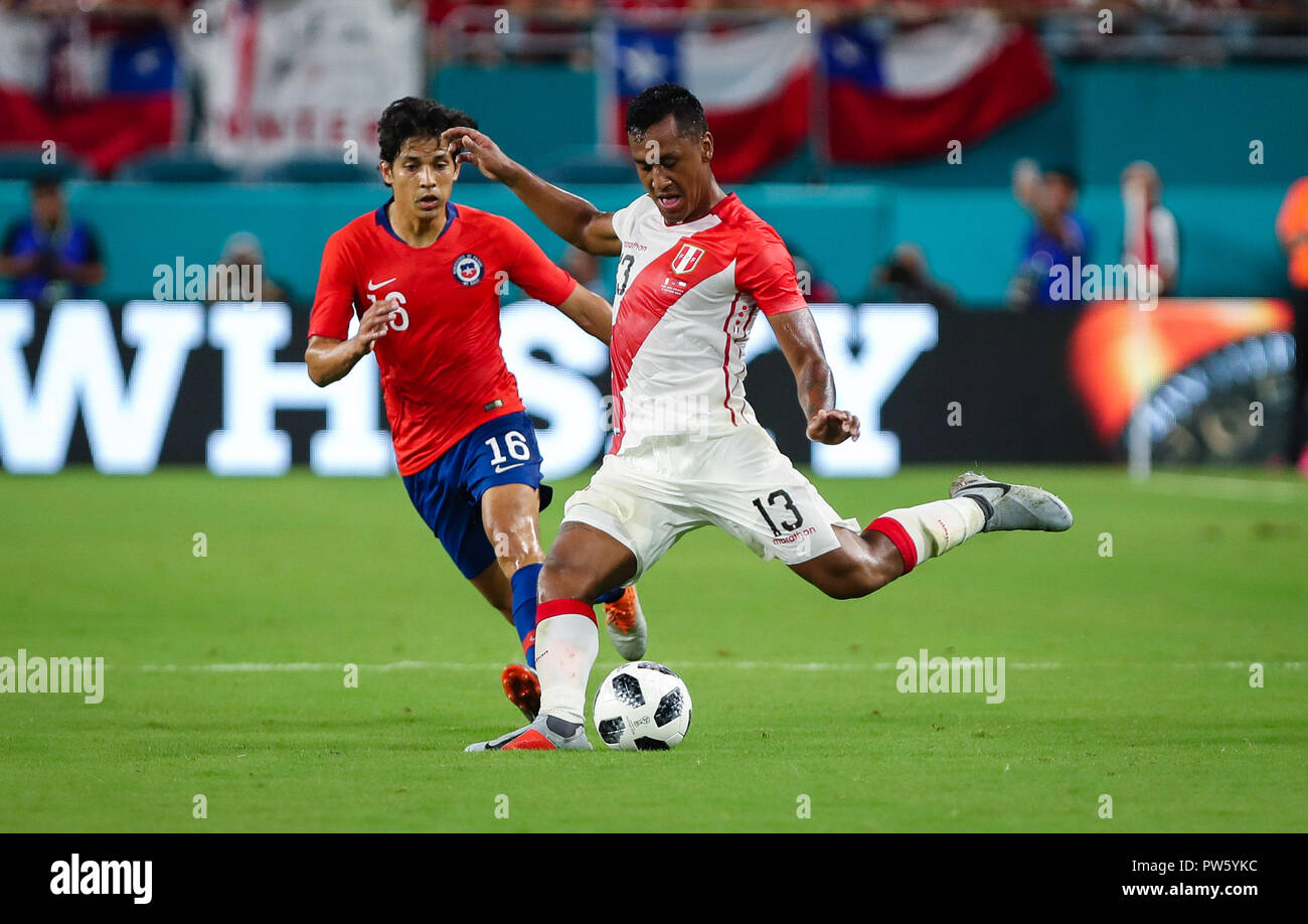 Miami Gardens, Florida, USA. 12th Oct, 2018. Peru midfielder RENATO TAPIA (13) kicks the ball defended by Chile midfielder MATIAS FERNANDEZ (16) during an international friendly match between the Peru and Chile national soccer teams, at the Hard Rock Stadium in Miami Gardens, Florida. Credit: Mario Houben/ZUMA Wire/Alamy Live News Stock Photo