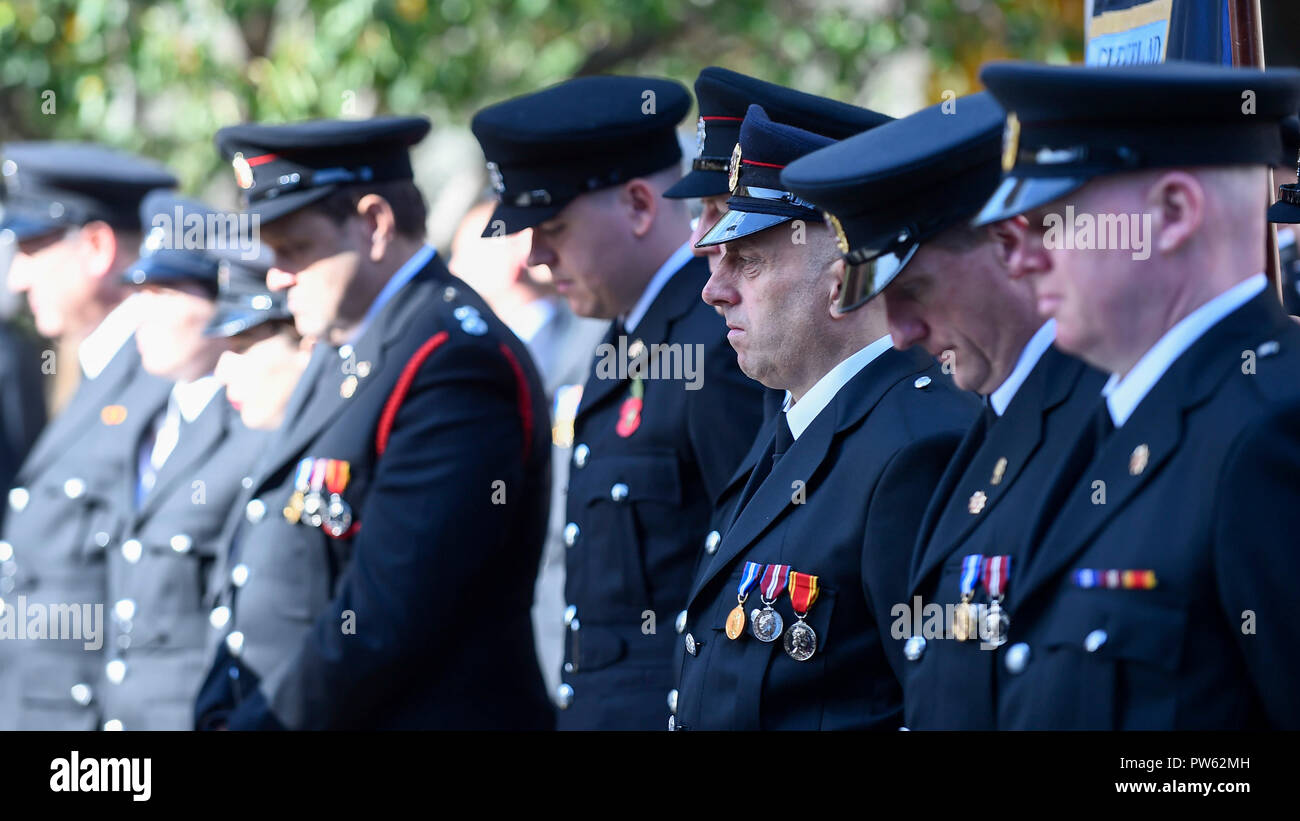 London, UK.  13 October 2018.  Members of the Fire Brigades Union (FBU) during a minute's silence in memory of fallen firefighters at the formal wreath-laying ceremony, one wreath for every fire service in the UK, at the National Firefighters’ Memorial next to St Paul’s Cathedral. The ceremony was followed by commemorations of the centenary of the formation of the FBU by a formal procession across the Millennium Bridge and a service at Southwark Cathedral. The activities are the largest ever ceremonial event for firefighters killed in the line of duty. Credit: Stephen Chung / Alamy Live News Stock Photo
