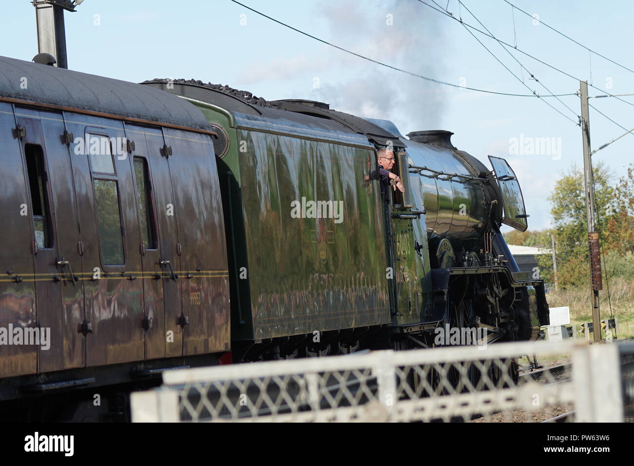 The Fireman on the footplate of Flying Scotsman as she leaves a siding on the East Coast Mail Line, having stopped to take on water during an excursion planned as a memorial to Alan Pegler, the man who saved the locomotive from the scrap yard in 1963.  Pictured here a few miles after the section at Sutton Bank where she secured the land speed record at 100mph in 1934 and where during the memorial run Alan Peglar's ashes were committed to the firebox. Stock Photo