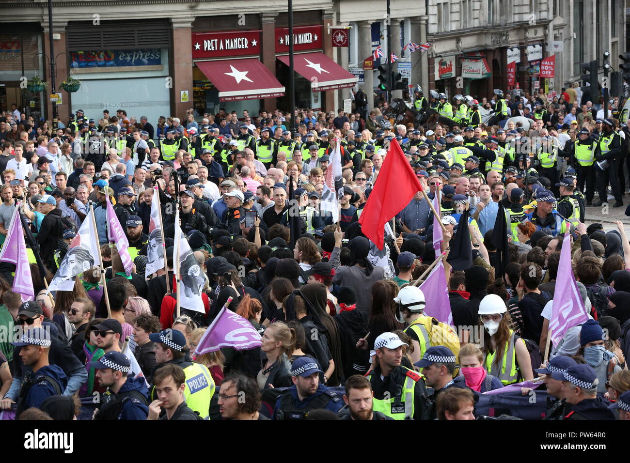 Central London, UK, 13th Oct 2018. Supporters of the the DFLA (Democratic Football Lads Alliance) marching through central London clash with Anti-Fascist groups between Trafalgar Square and Whitehall, under heavy police presence. Police try to establish a visible security line with armoured vans, horses and officers between the two sides. Credit: Imageplotter News and Sports/Alamy Live News Stock Photo