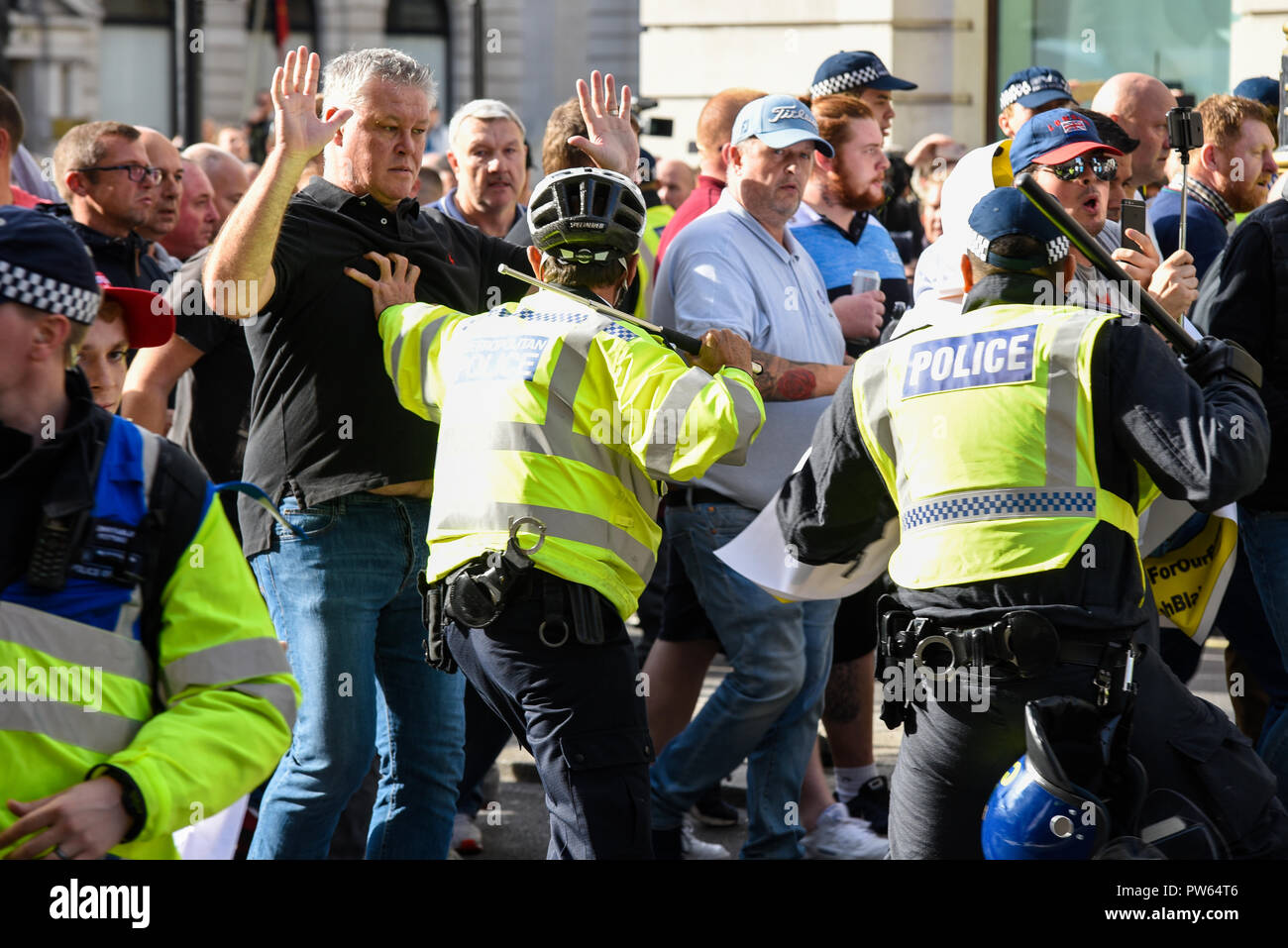 Democratic Football Lads Alliance DFLA marching towards Parliament, London, in protest demonstration. Marchers broke through a police cordon and scuffles took place. Cycle officer with telescopic baton stick Stock Photo