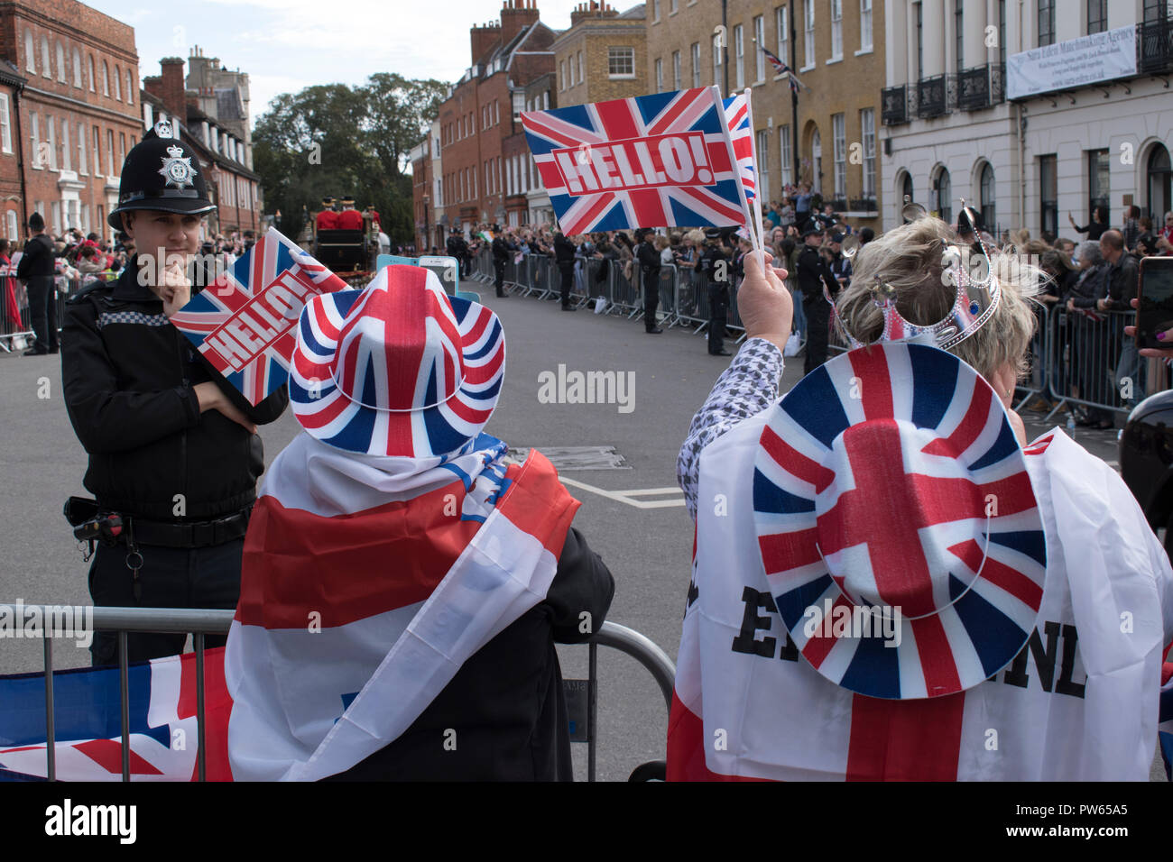 Royal wedding of Princess Eugenie of York and Jack Brooksbank group patriotic women wearing Union Jack clothes wave as royal coach with Princess Eugenie and her new husband Jack drive past into grounds of Windsor castle. Windsor October 2018 Uk HOMER SYKES Stock Photo