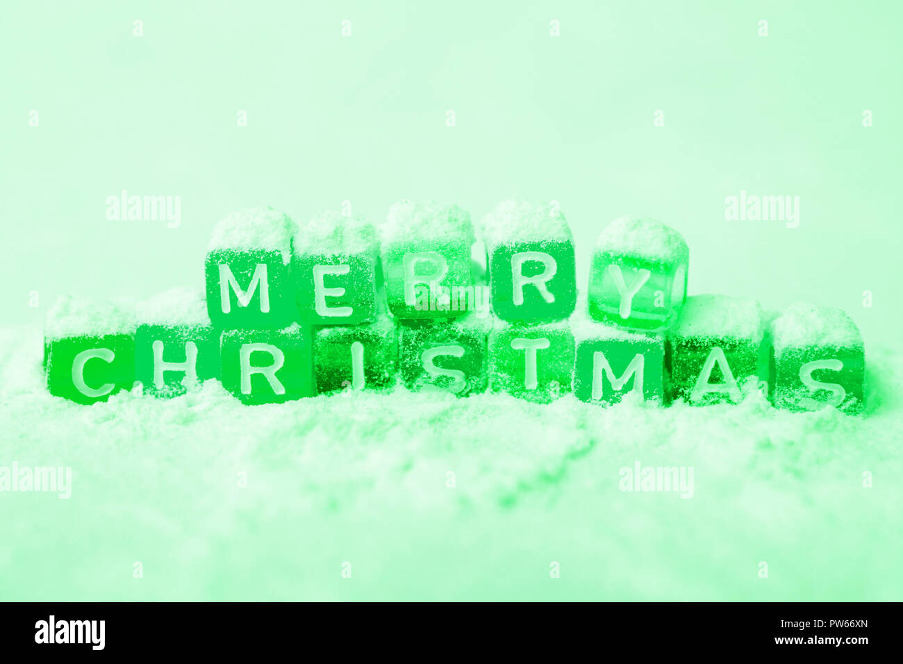 words merry christmas made of colorful blocks on pink background. greem