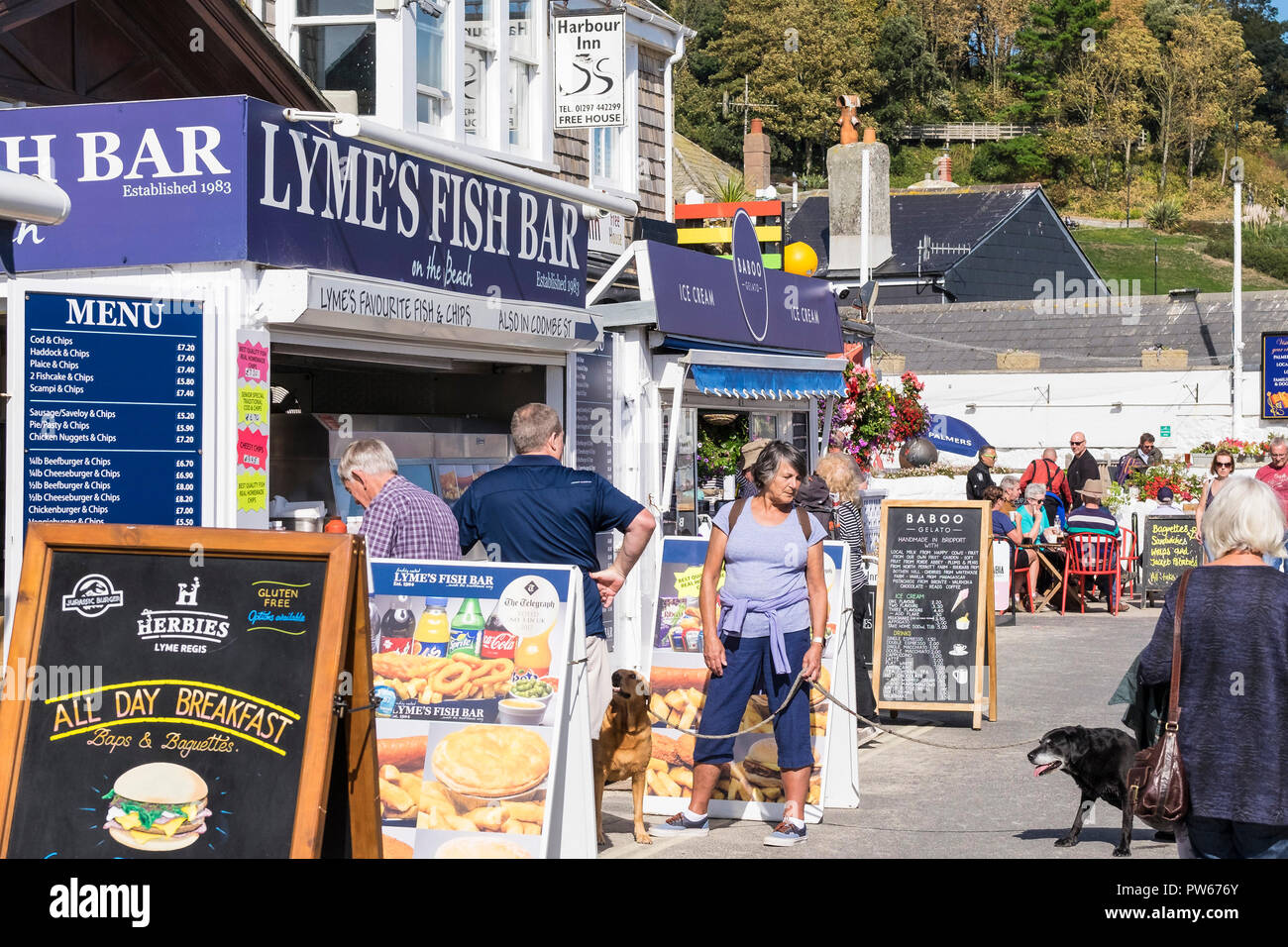 Customers at the Lyme Fish bar on Marine Parade in the coastal town of Lyme Regis in Dorset. Stock Photo