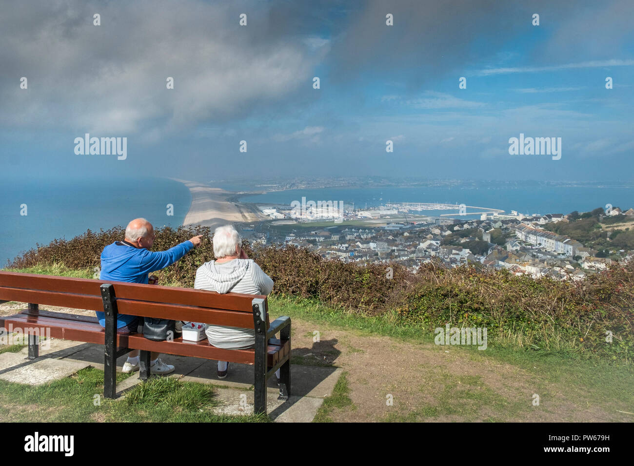 A mature couple enjoying the view from the summit of the Isle of Portland in Dorset UK. Stock Photo