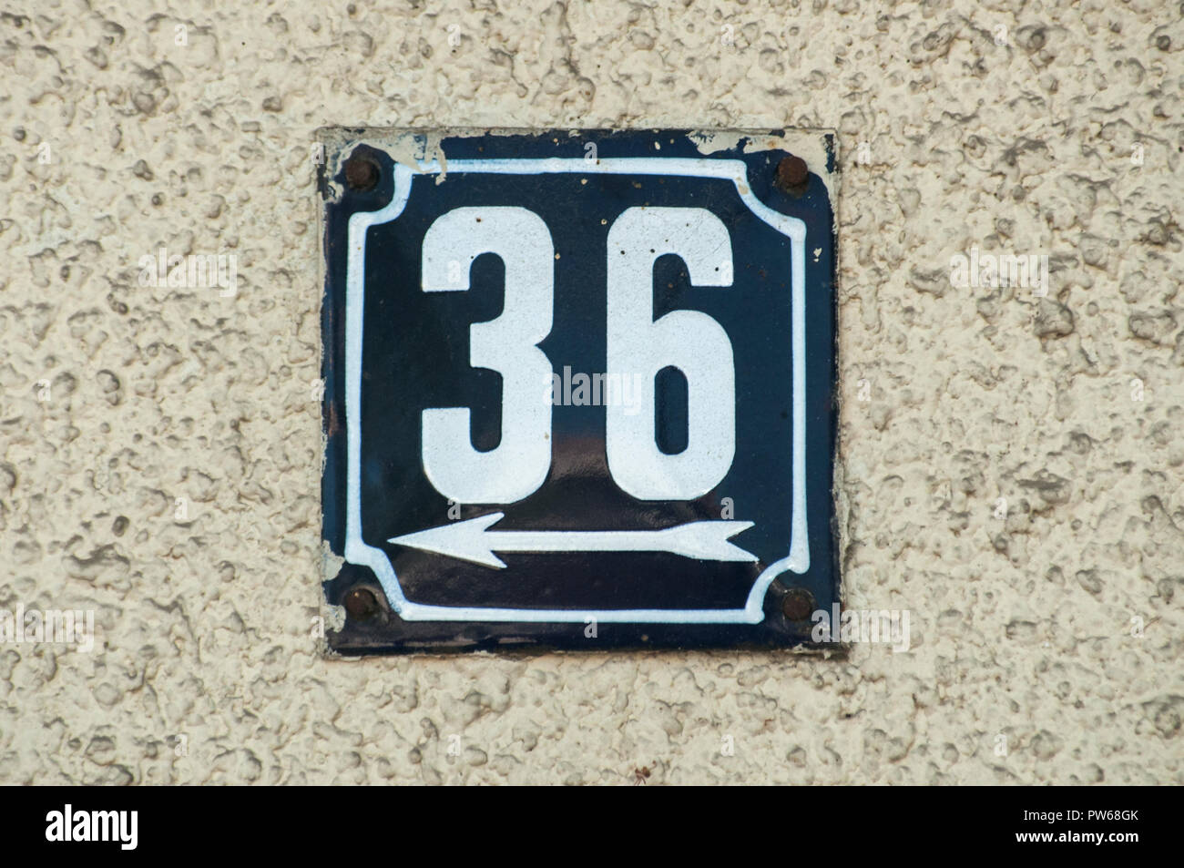 Weathered grunge square metal enameled plate of number of street address with number 36 closeup Stock Photo