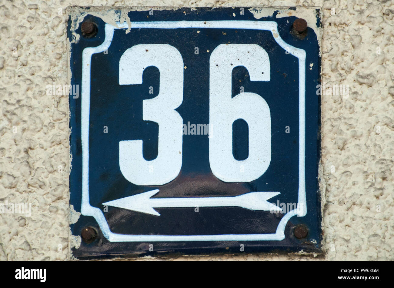 Weathered grunge square metal enameled plate of number of street address with number 36 closeup Stock Photo