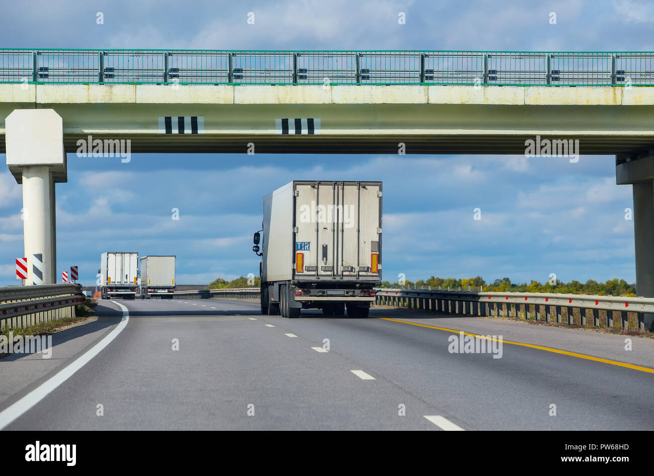 Trucks move under a viaduck. Two-way traffic. Stock Photo