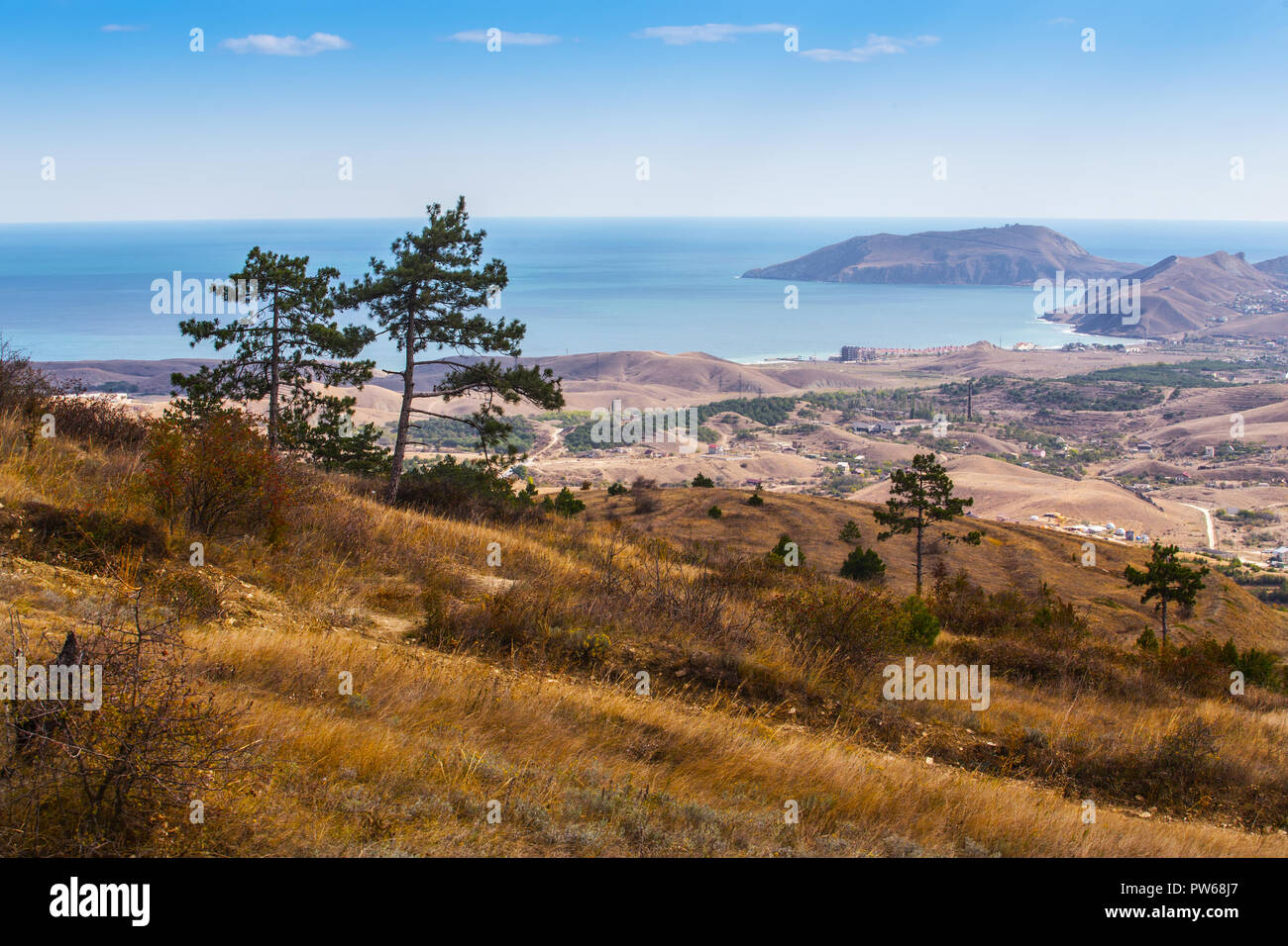 colorful view of the sea, hilly island and cottages in the distance Stock Photo