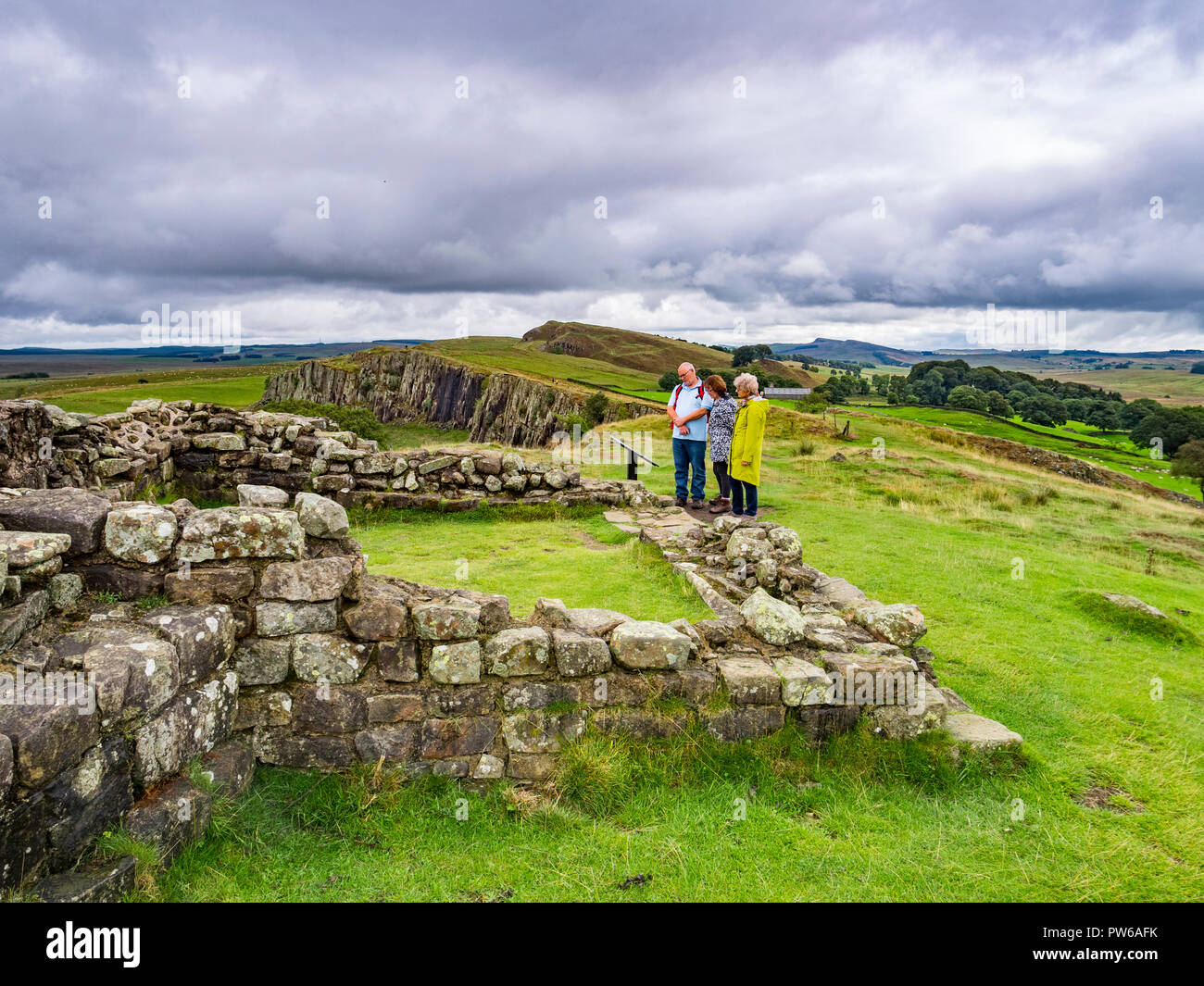 13 August 2018: Hadrian's Wall, Northumberland - Group of walkers at Turret 45A on Hadrians' Wall near Walltown Crags under a dramatic sky. Stock Photo