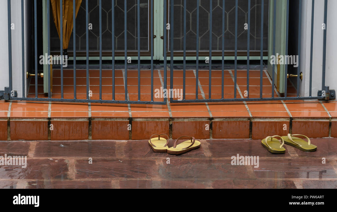 Shoes in the rain outside a temple Stock Photo