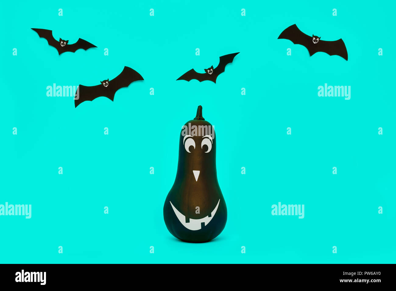 Cute Halloween pumpkin with funny smiling face and paper bats flying ...
