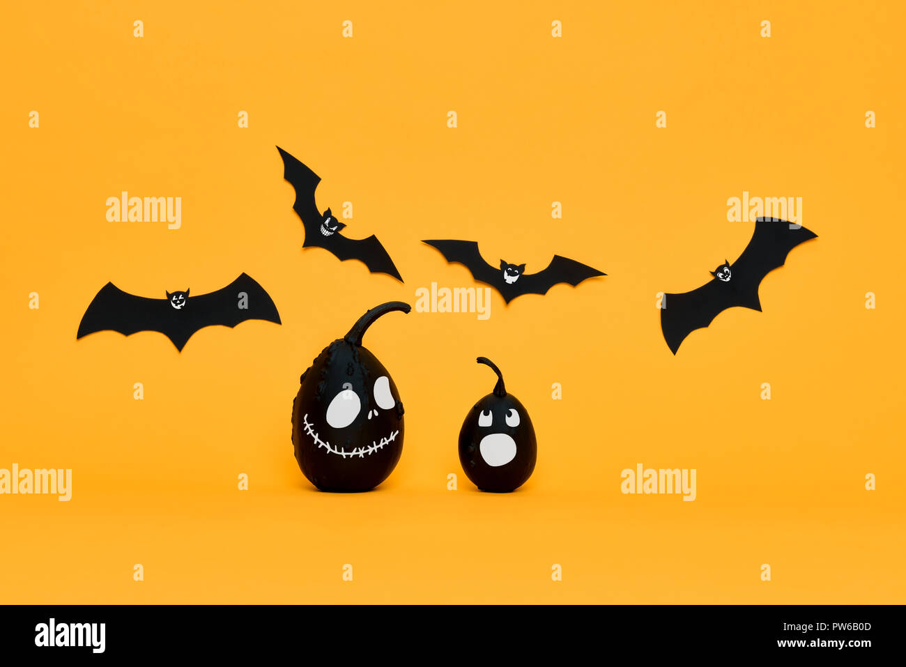 Cute Halloween pumpkins with funny smiling faces and paper bats flying ...