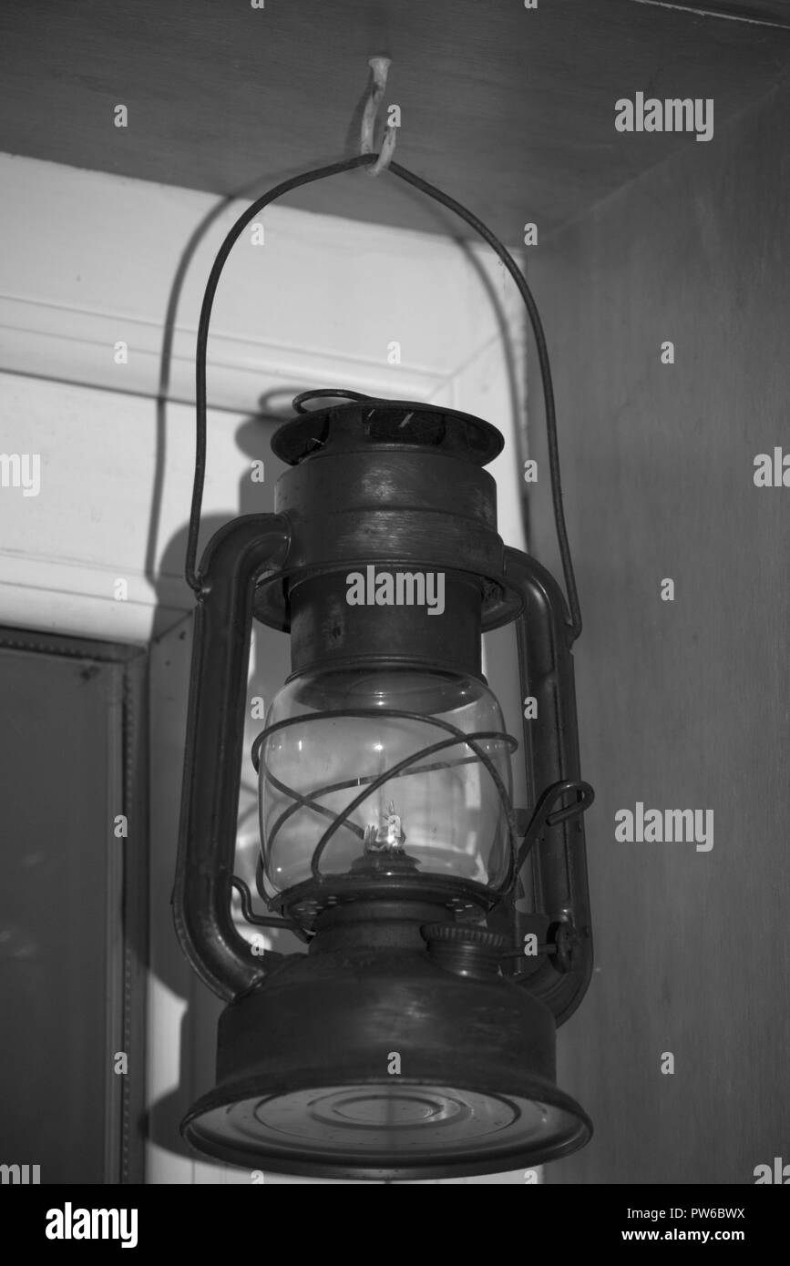 Kerosene or hurricane lamp framed in a doorway, black and white Stock