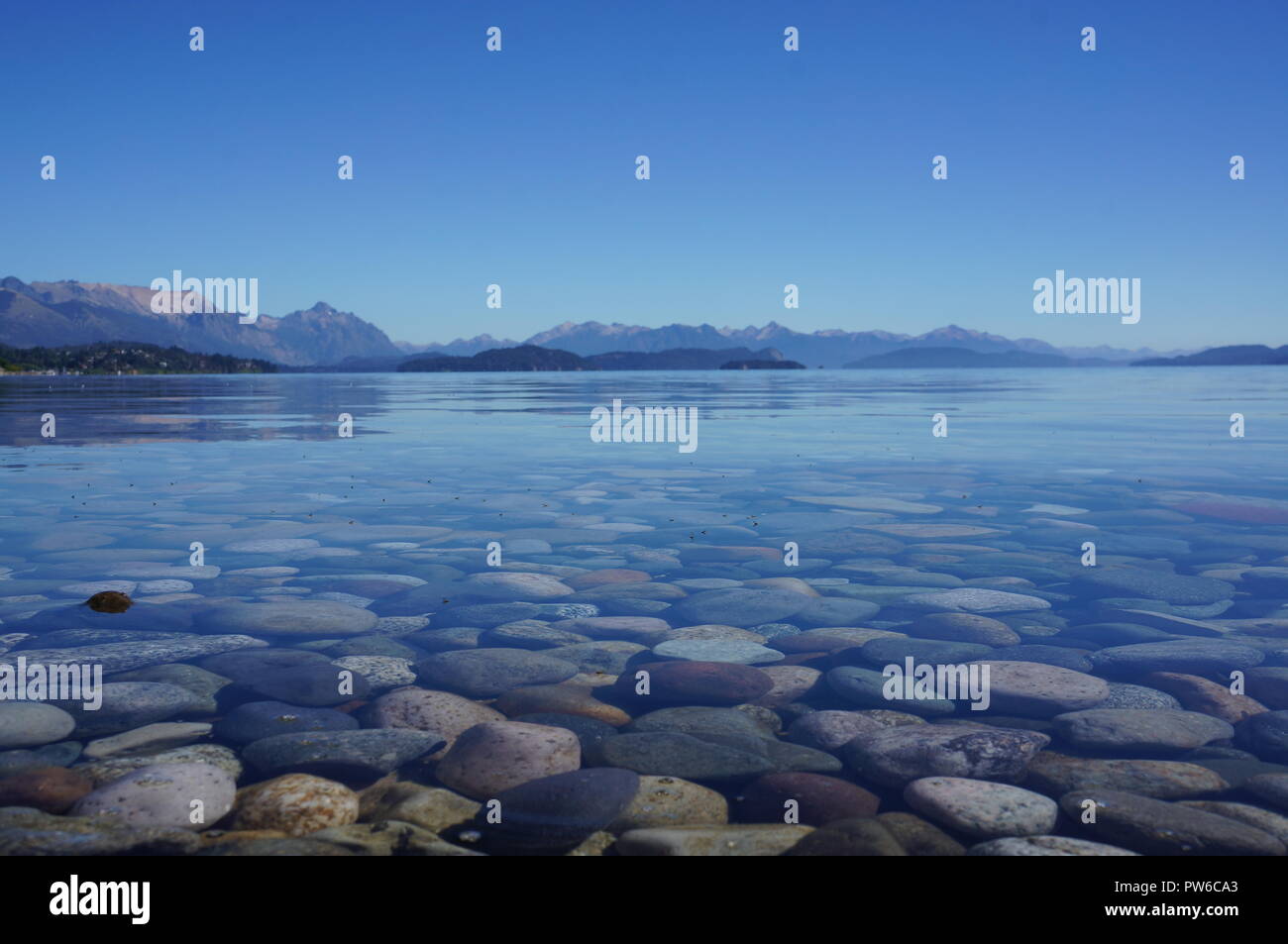 Calm waters on Nahuel Huapi Lake in Bariloche surrounded by beautiful mountains and blue skies, Argentina, South America. Stock Photo