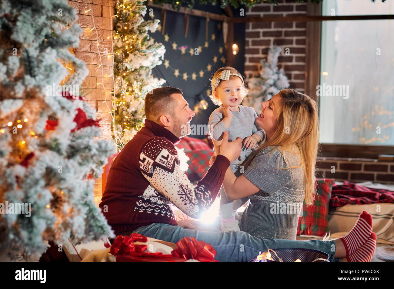 Happy family with a baby in a Christmas room. Stock Photo
