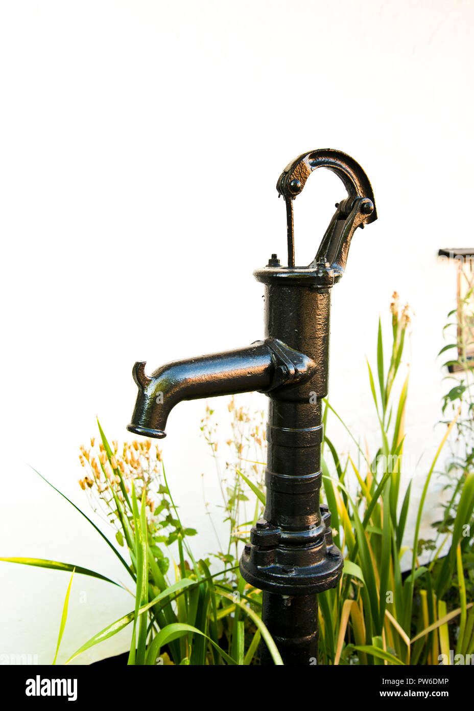 A traditional old / vintage probably Victorian or Edwardian era, hand pump water pump in the garden of an 18th-century house Stock Photo