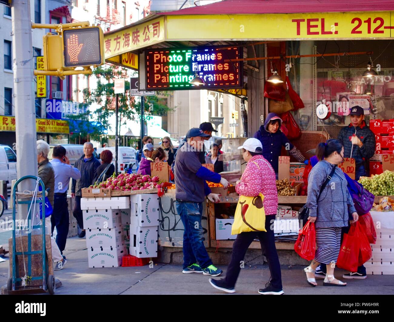 Asian shoppers outside vegetable, fruit market on corner of Mott Street in Chinatown, New York, NY, USA. Stock Photo
