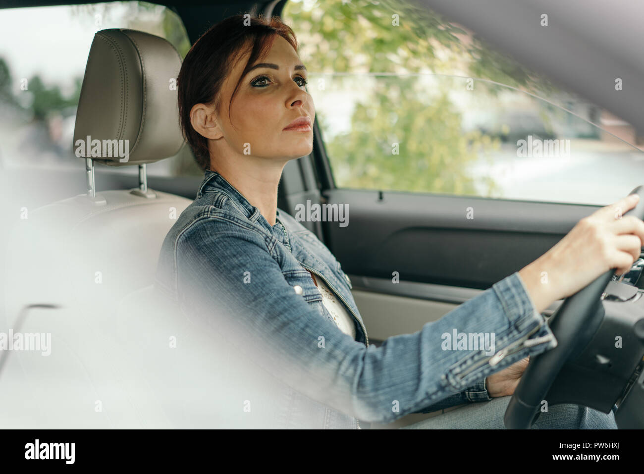 Woman driving car on road commuting Stock Photo
