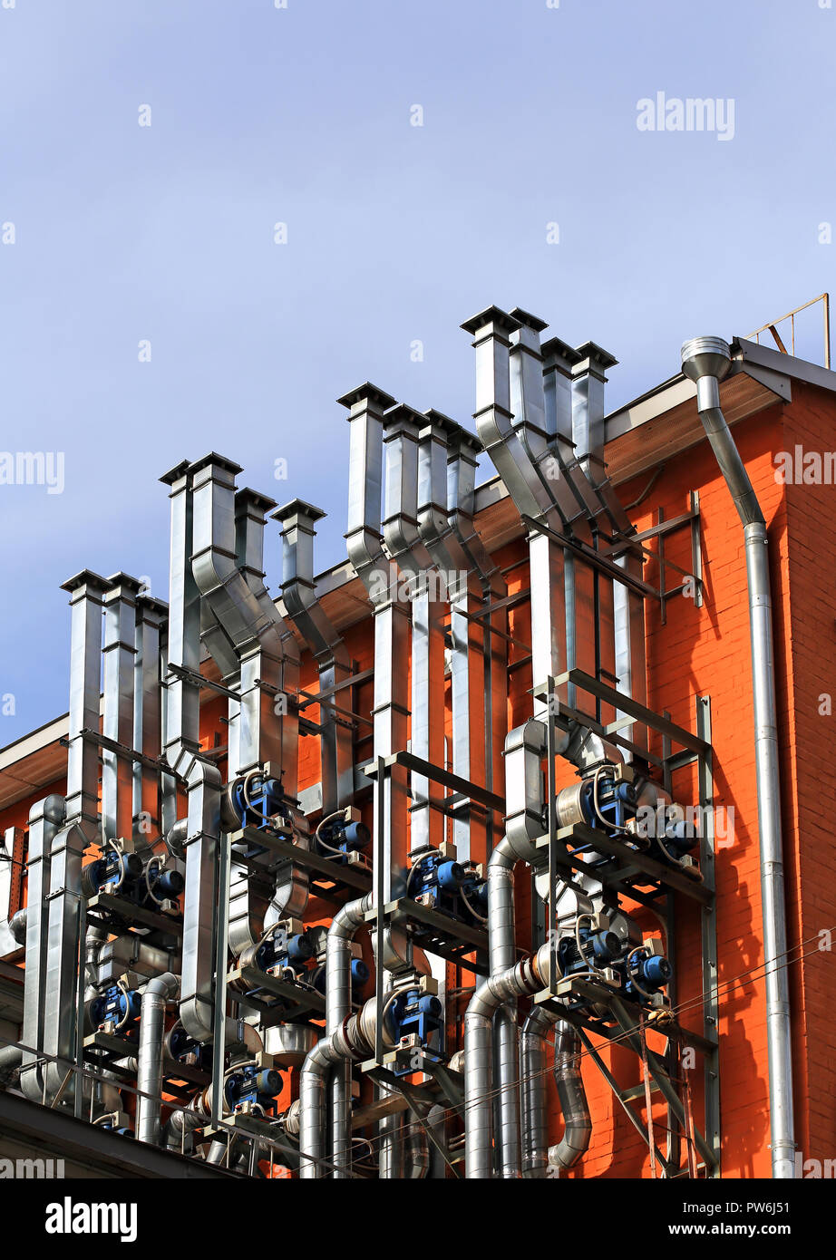 Ventilation pipes and actuators on the wall of an industrial building Stock Photo
