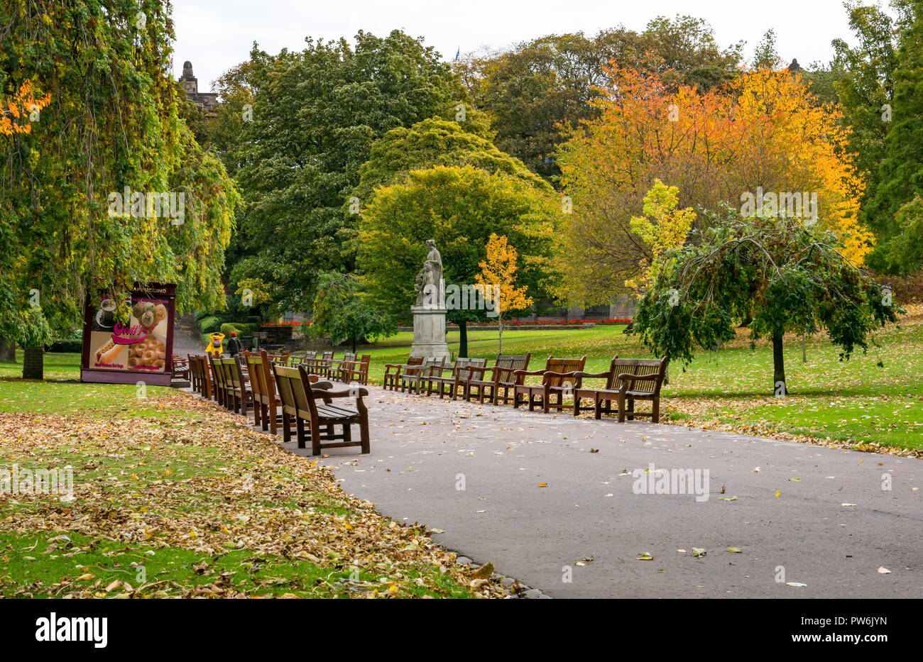 Wooden benches in Princes Street Gardens with Autumn leaf colours