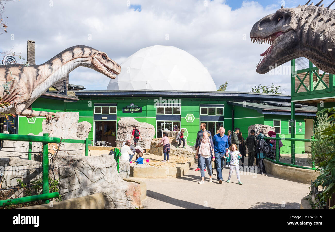 Gulliver's Dinosaur & Farm Park, Lost World - Milton Keynes, UK. Entrance of the park with people visiting and big dinosaurs replicas Stock Photo