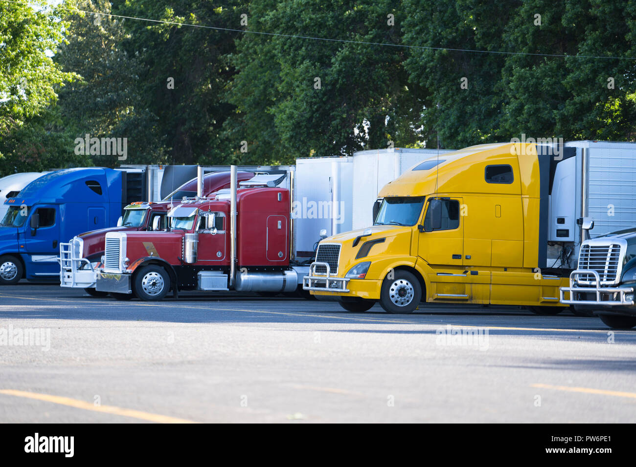 Popular big rigs semi trucks of different makes and models standing in